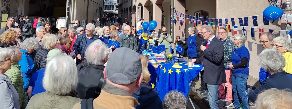 Menschen lauschen der Eröffnungsrede von Ulrich von Kirchbach zur Blauen Pause.